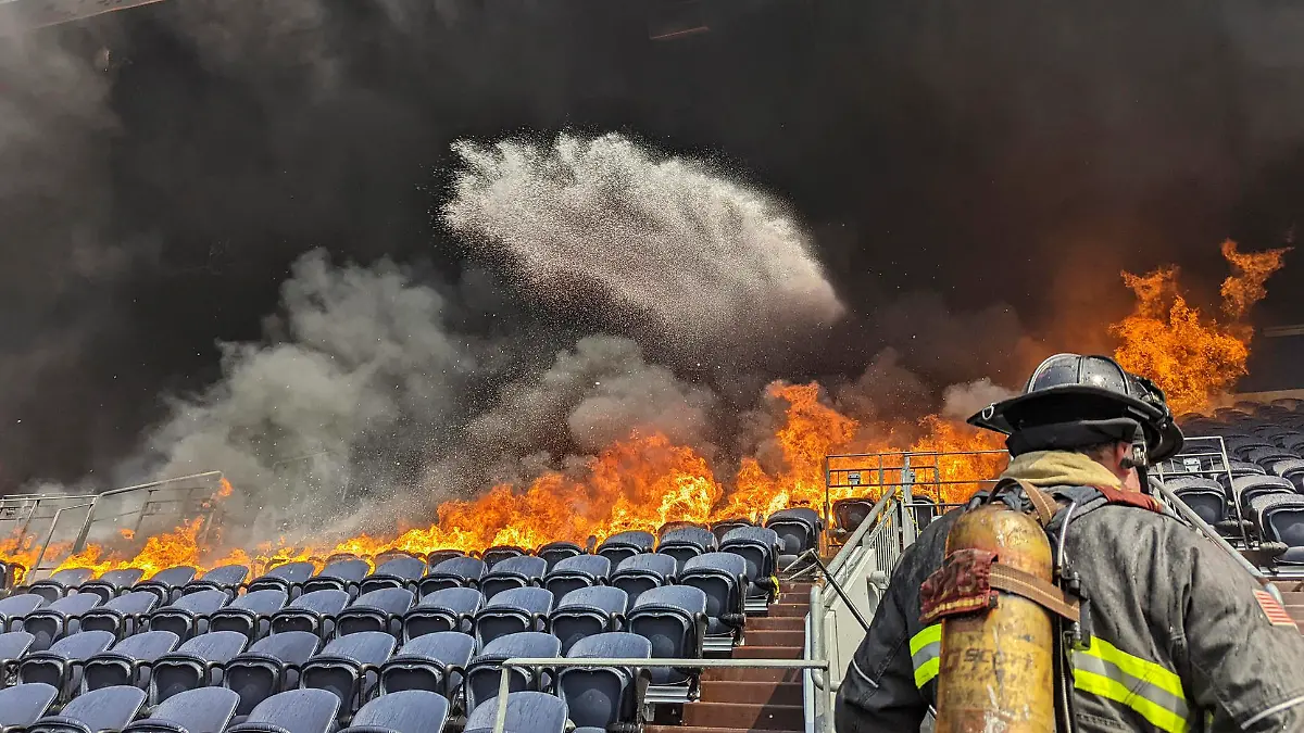 HANDOUT - 24.03.2022, USA, Denver: Auf diesem von der Feuerwehr Denver zur Verfügung gestellten Bild bekämpfen Feuerwehrleute die Flammen im Empower Field im Mile High Stadion in Denver. Feuerwehrleute haben einen Brand gelöscht, der mehrere Sitzreihen und einen Suitenbereich im Stadion der Denver Broncos in Brand gesetzt hat. Das Feuer brach auf der dritten Ebene aus und verbrannte mindestens sechs Sitzreihen in zwei Abschnitten. Foto: Uncredited/enver Fire Department via AP/dpa - ACHTUNG: Nur zur redaktionellen Verwendung und nur mit vollständiger Nennung des vorstehenden Credits +++ dpa-Bildfunk +++