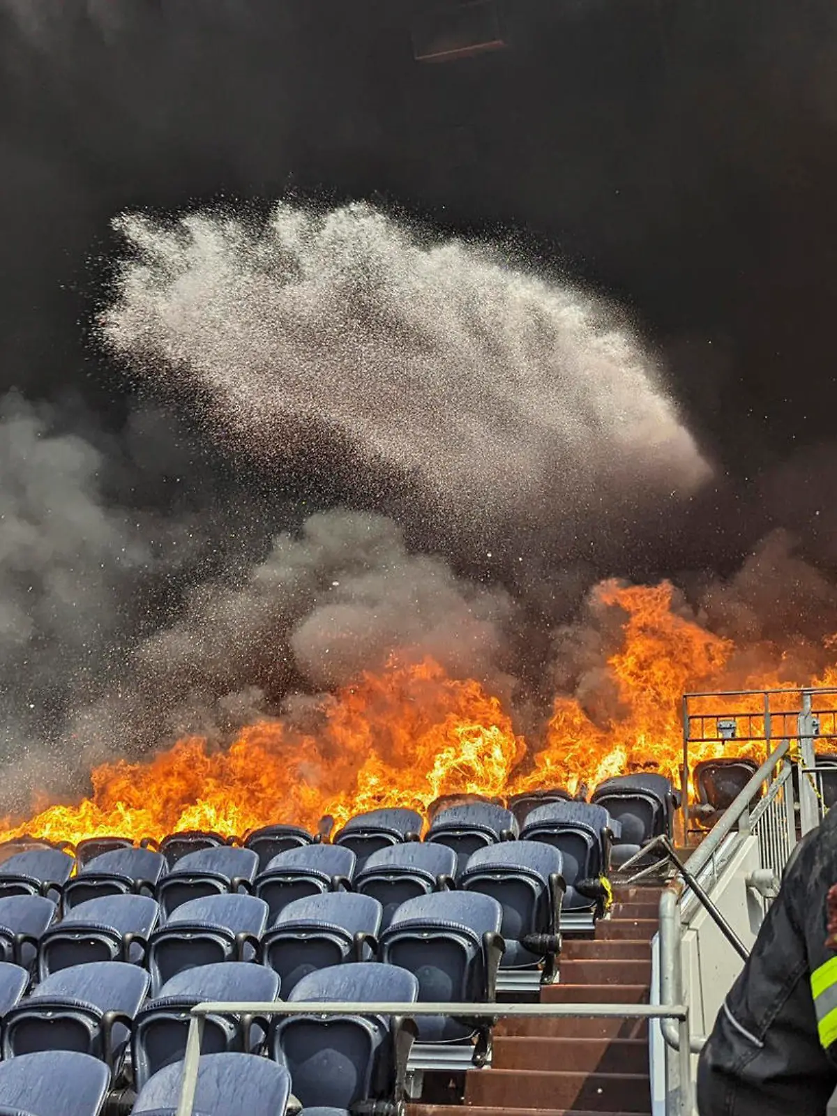 HANDOUT - 24.03.2022, USA, Denver: Auf diesem von der Feuerwehr Denver zur Verfügung gestellten Bild bekämpfen Feuerwehrleute die Flammen im Empower Field im Mile High Stadion in Denver. Feuerwehrleute haben einen Brand gelöscht, der mehrere Sitzreihen und einen Suitenbereich im Stadion der Denver Broncos in Brand gesetzt hat. Das Feuer brach auf der dritten Ebene aus und verbrannte mindestens sechs Sitzreihen in zwei Abschnitten. Foto: Uncredited/enver Fire Department via AP/dpa - ACHTUNG: Nur zur redaktionellen Verwendung und nur mit vollständiger Nennung des vorstehenden Credits +++ dpa-Bildfunk +++