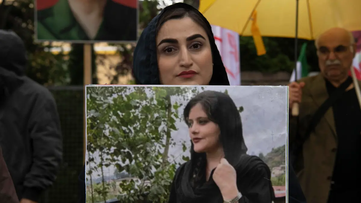 20.09.2022, Berlin: Bei einem Protest des Nationalen Widerstandsrates Iran (NWRI) vor der iranischen Botschaft in Berlin hält eine Frau ein Bild der verstorbenen Mahsa Amini in Händen. Die junge Frau war am vergangenen Dienstag von der Sitten- und Religionspolizei wegen ihres «unislamischen Outfits» festgenommen worden. Foto: Paul Zinken/dpa - ACHTUNG: Nur zur redaktionellen Verwendung und nur mit vollständiger Nennung des vorstehenden Credits +++ dpa-Bildfunk +++