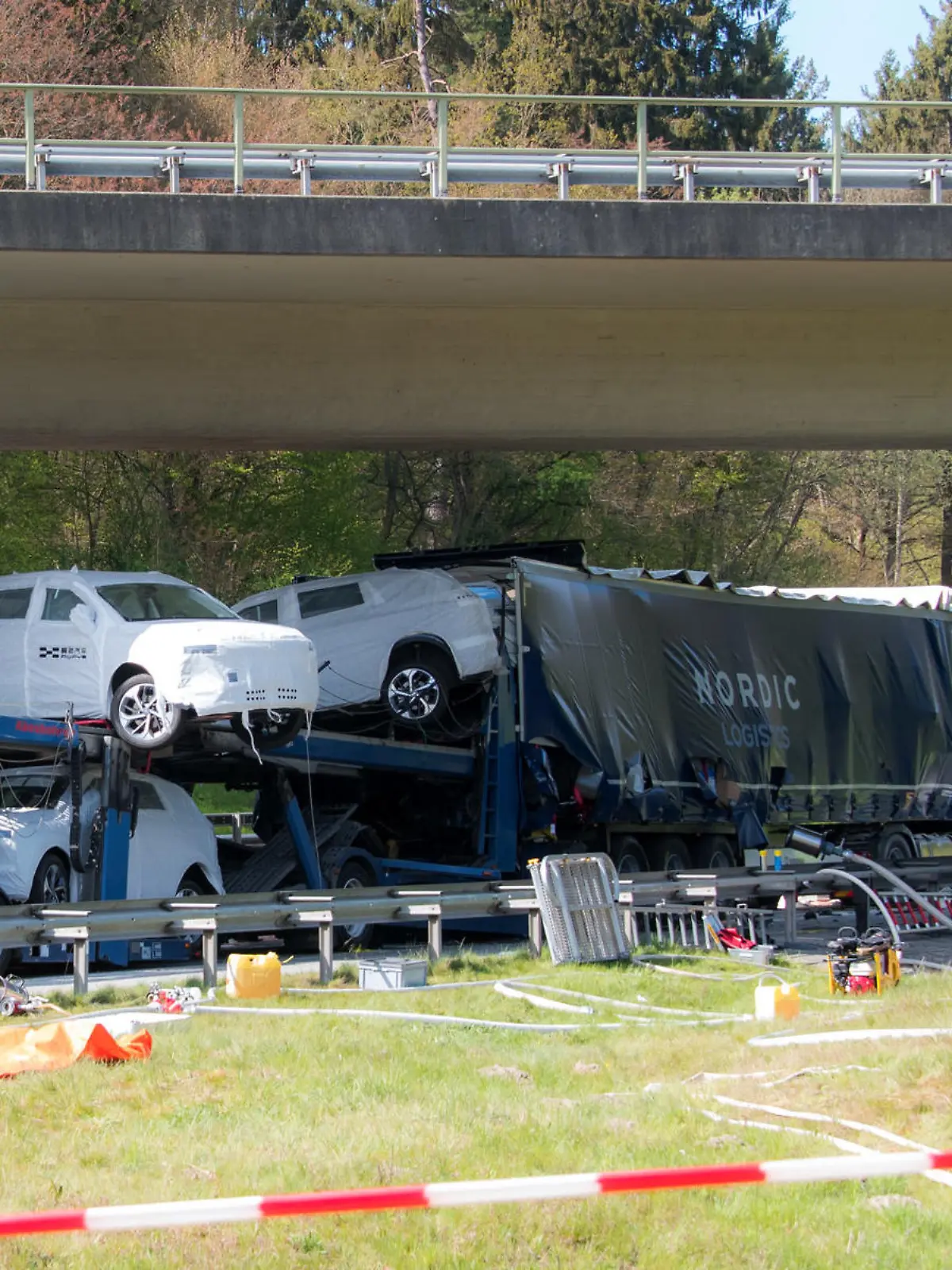 27.04.2022, Hamburg: Einsatzkräfte stehen auf der Autobahn A261 im Stadtteil Marmstorf an einer Unfallstelle. Ein Autotransporter ist auf einen Sattelzug aufgefahren, der Fahrer kam dabei ums Leben. Foto: Daniel Bockwoldt/dpa +++ dpa-Bildfunk +++