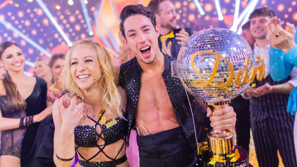 Rene Casselly, Zirkusartist, und Kathrin Menzinger, Profitänzerin, jubeln mit dem Pokal nach dem Sieg in der RTL-Tanzshow "Let's Dance" im Coloneum.