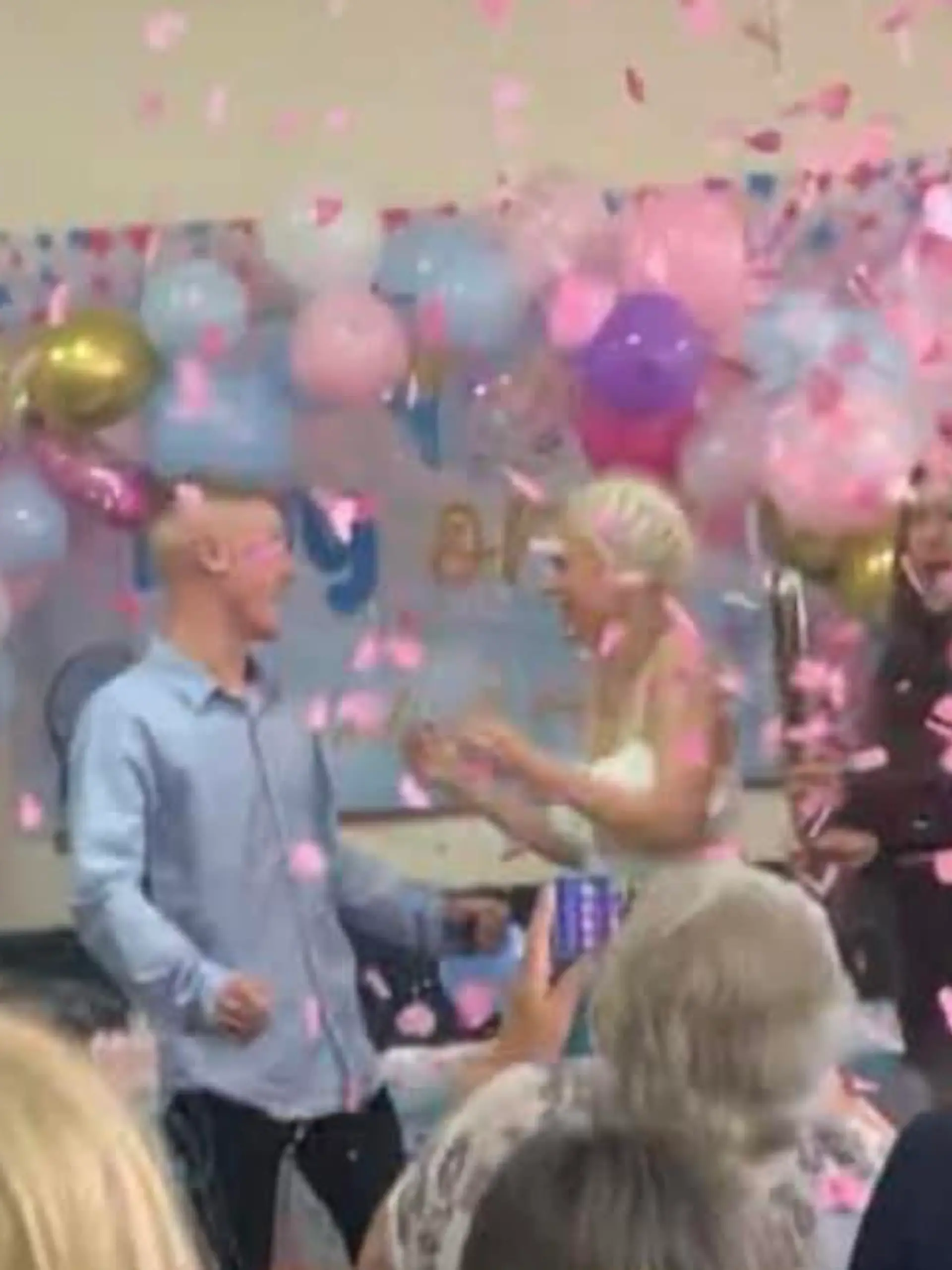 Ein Mann auf einer Party, um ihn sind andere Menschen und Luftballons