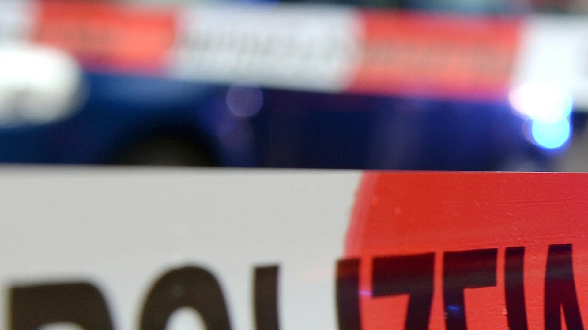 ARCHIV - ILLUSTRATION - Ein Flatterband mit der Aufschrift «Polizeiabsperrung» ist am 05.11.2014 in Freiburg (Baden-Württemberg) an einem Einsatzort vor einem Feuerwehrfahrzeug mit Blaulicht zu sehen.  Ein Fußgänger ist am 16.06.2017 bei einem illegalen Autorennen in Mönchengladbach (Nordhrein-Westfalen) getötet worden. (zu dpa "Fußgänger bei illegalem Autorennen in Mönchengladbach getötet" vom 17.06.2017) Foto: Patrick Seeger/dpa +++(c) dpa - Bildfunk+++