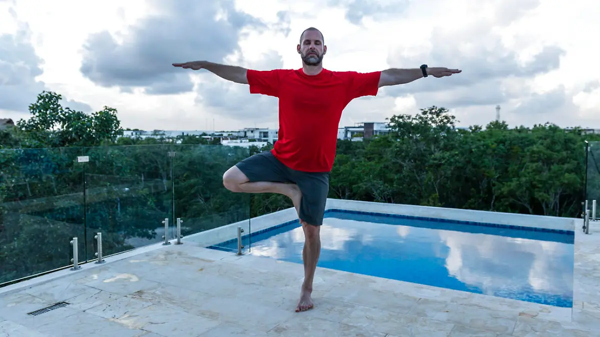 He balances in tree pose, while on a tropical holiday at a luxury hotel