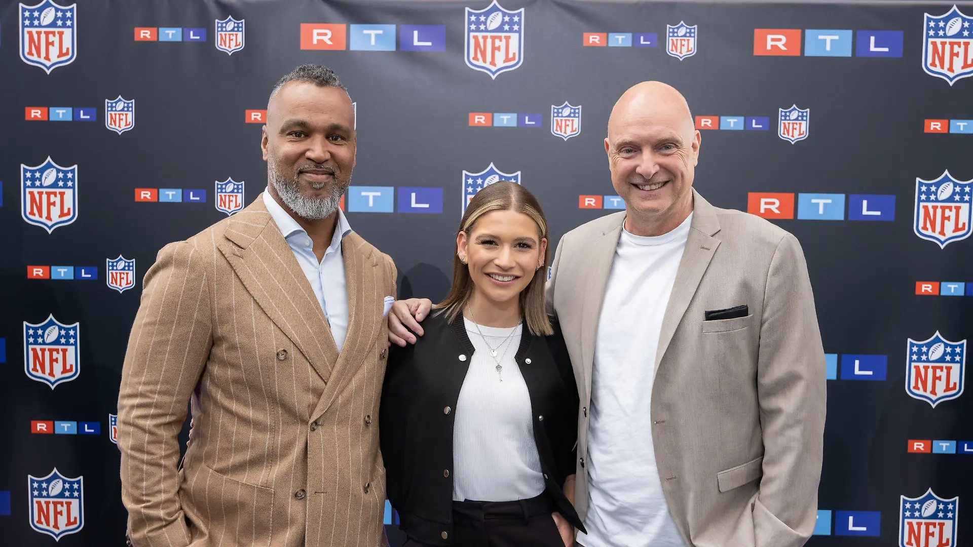 ARCHIV - 26.05.2023, Hessen, Frankfurt am Main: TV-Experte Patrick Esume (l) und die TV-Moderatoren Jana Wosnitza und Frank Buschmann stehen beim Presseevent zusammen. Die RTL-Gruppe beginnt ihre NFL-Übertragungen. (zu dpa: «Erste Football-Übertragung bei neuem Sender») Foto: Jürgen Kessler/dpa +++ dpa-Bildfunk +++