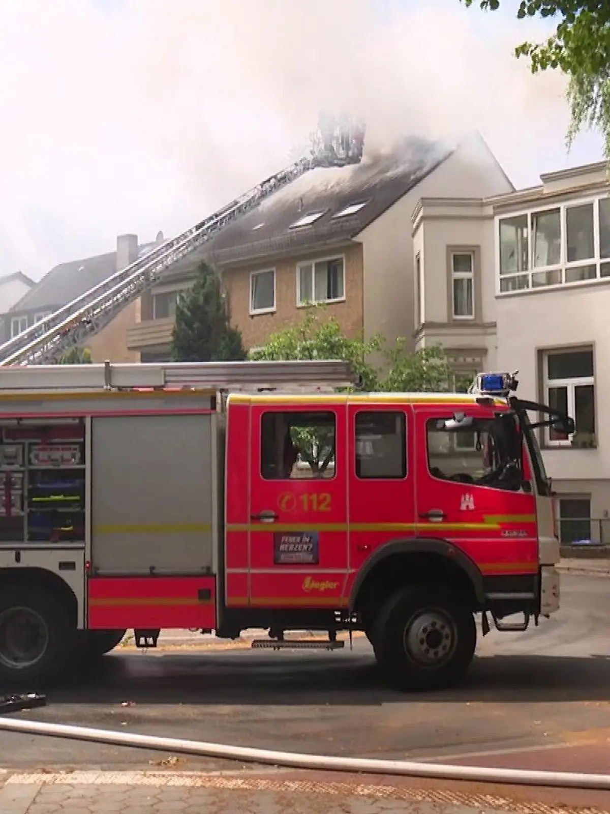 Schwarzer Rauch steigt aus einem Mehrfamilienhaus in Hamburg-Hamm.