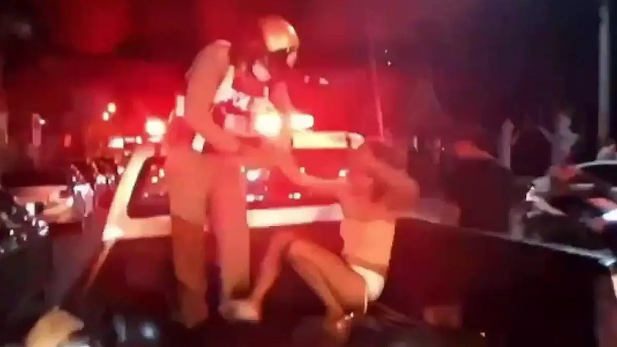 Ein Polizist versucht die betrunkene Prostituierte auf einem Truck zu fesseln.