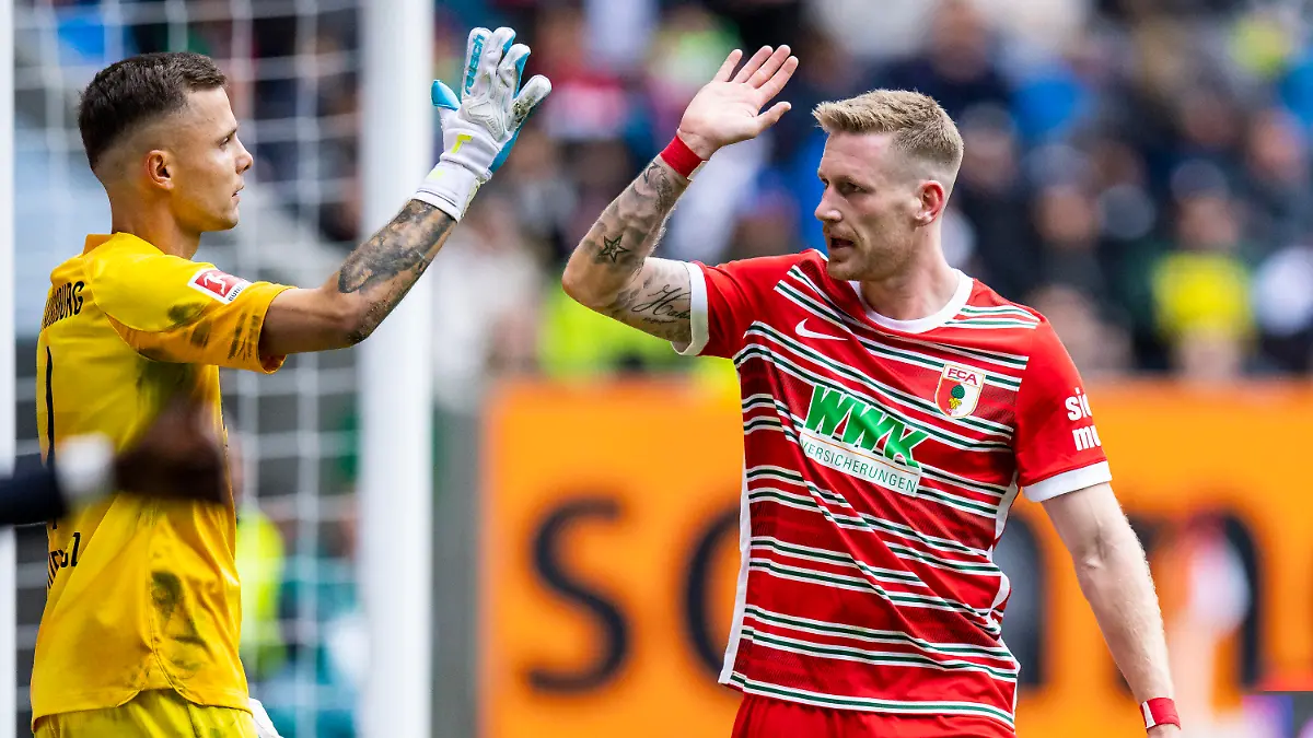 17.09.2022, Bayern, Augsburg: Fußball: Bundesliga, FC Augsburg - Bayern München, 7. Spieltag, WWK-Arena. Augsburgs Torwart Rafal Gikiewicz (l) klatscht mit Augsburgs Andre Hahn (r) ab. Foto: Tom Weller/dpa - WICHTIGER HINWEIS: Gemäß den Vorgaben der DFL Deutsche Fußball Liga bzw. des DFB Deutscher Fußball-Bund ist es untersagt, in dem Stadion und/oder vom Spiel angefertigte Fotoaufnahmen in Form von Sequenzbildern und/oder videoähnlichen Fotostrecken zu verwerten bzw. verwerten zu lassen. +++ dpa-Bildfunk +++
