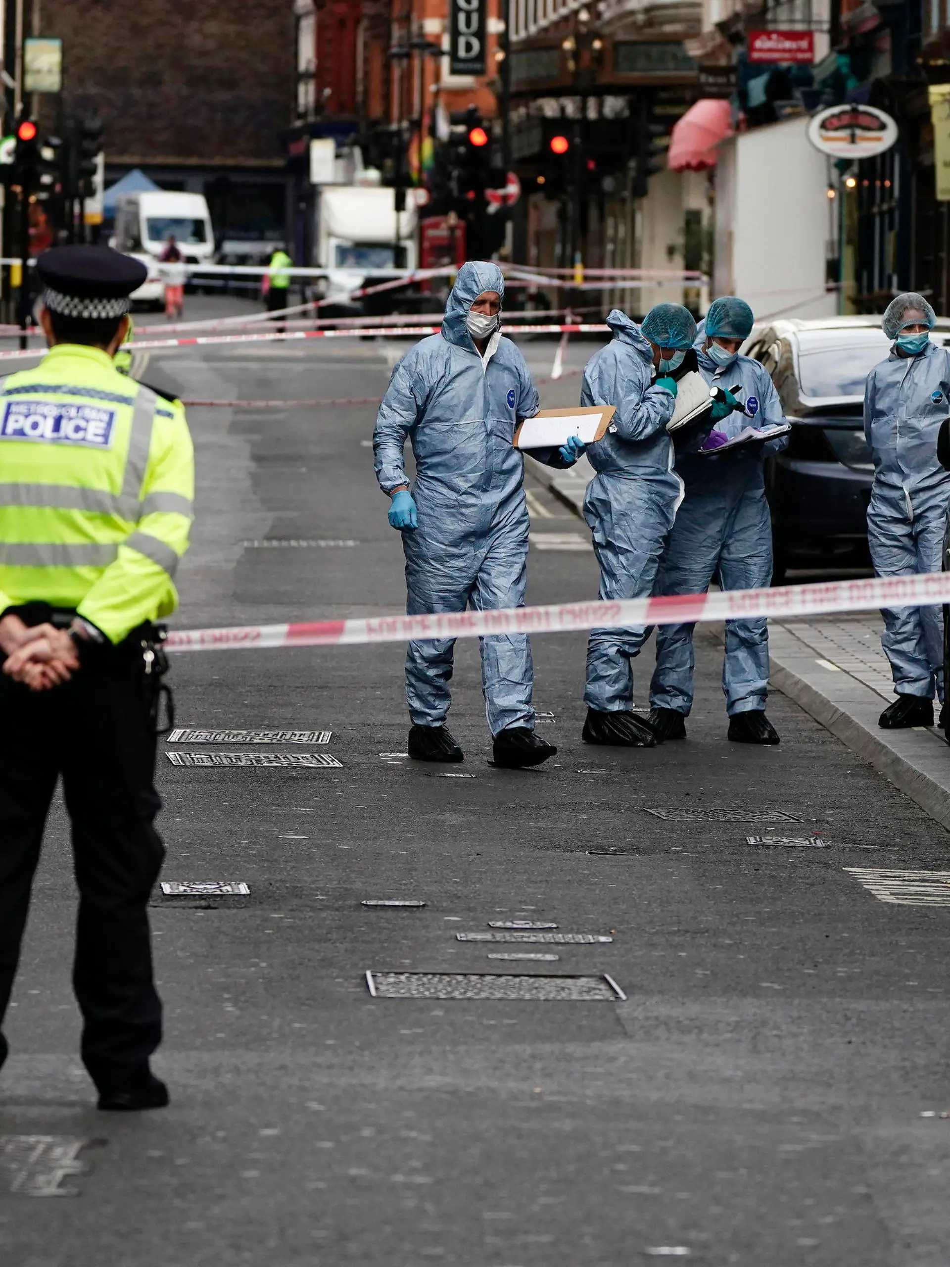 Forensics officers and police at the scene in Shaftesbury Avenue, where two male police officers were stabbed, in London, Friday, Sept. 16, 2022.  London’s police force says two officers have been hospitalized after being stabbed in central London early Friday. It says the attack is not being treated as terrorism. The Metropolitan Police force says officers “encountered a man with a knife” in the Leicester Square area, a busy tourist hub, at around 6 a.m. (Aaron Chow/PA via AP)
