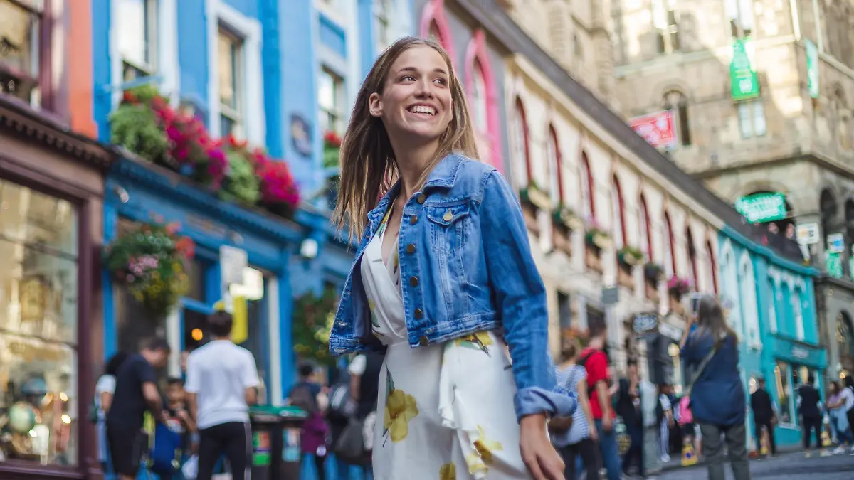 Beautiful young woman in dress, exploring architectural beauty of Victoria street ina Edinburgh on a sunny summer day