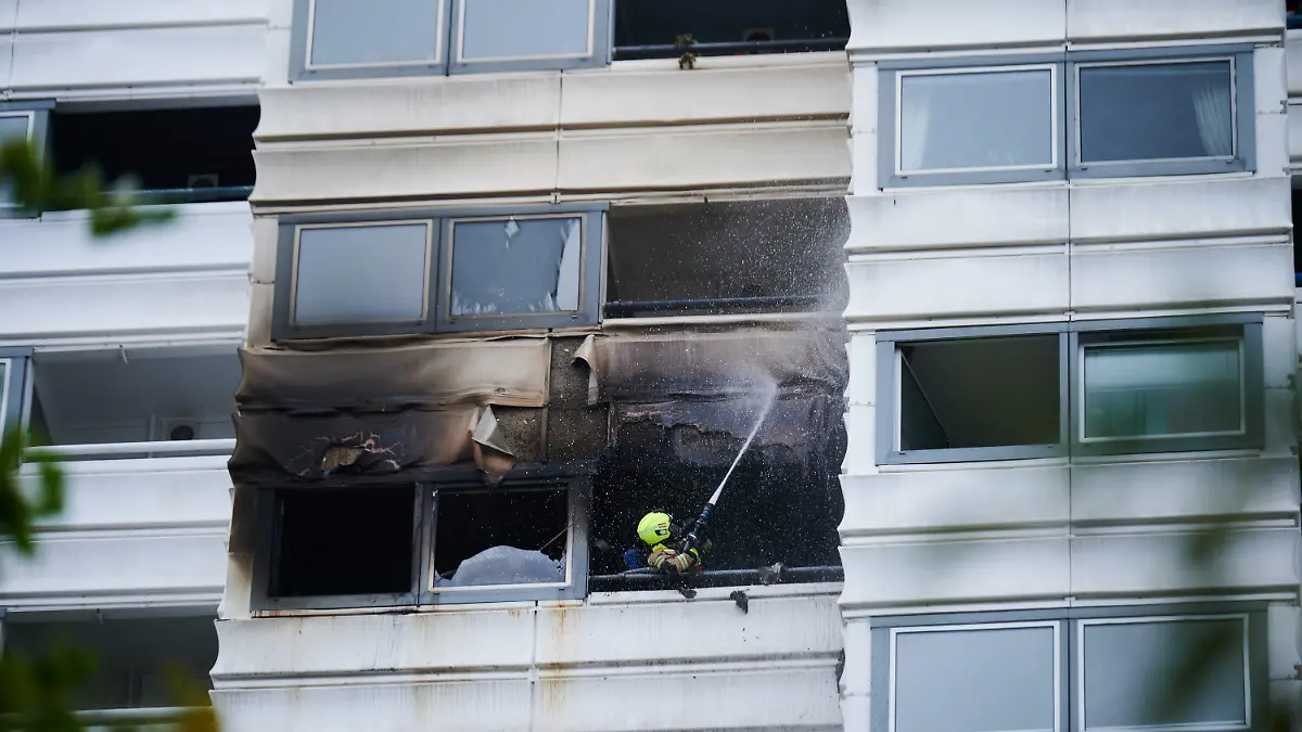 28.07.2023, Berlin: Ein Feuerwehrmann löscht einen Brand in einem Hochhaus. Wegen eines Brandes im zwölften Stock eines Hochhauses in Berlin sind zwei Menschen aus dem Gebäude gesprungen und ums Leben gekommen. Sie starben trotz Reanimation noch an der Unfallstelle, wie ein Feuerwehrsprecher sagte. Das Feuer sei am Freitag im zwölften Stock eines Hochhauses in Berlin-Kreuzberg ausgebrochen. Foto: Annette Riedl/dpa +++ dpa-Bildfunk +++