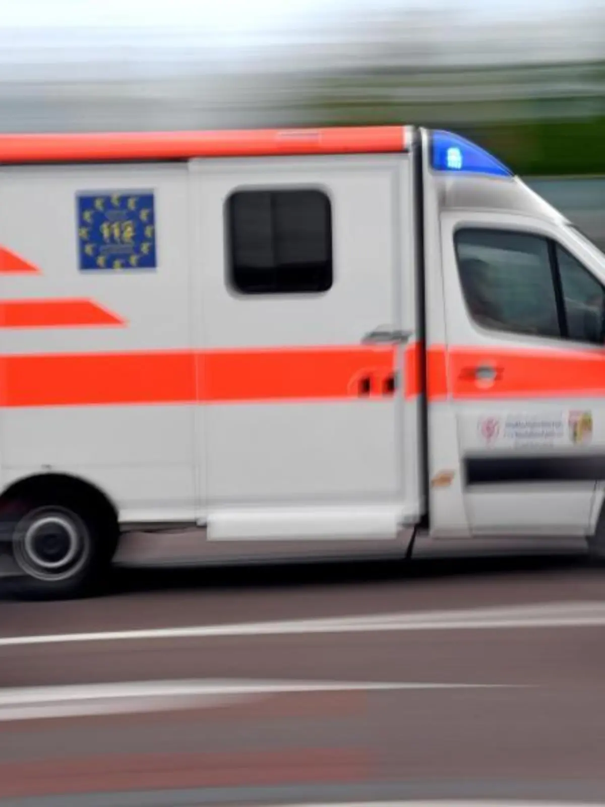 Ein Krankenwagen fährt mit Blaulicht über eine Straße