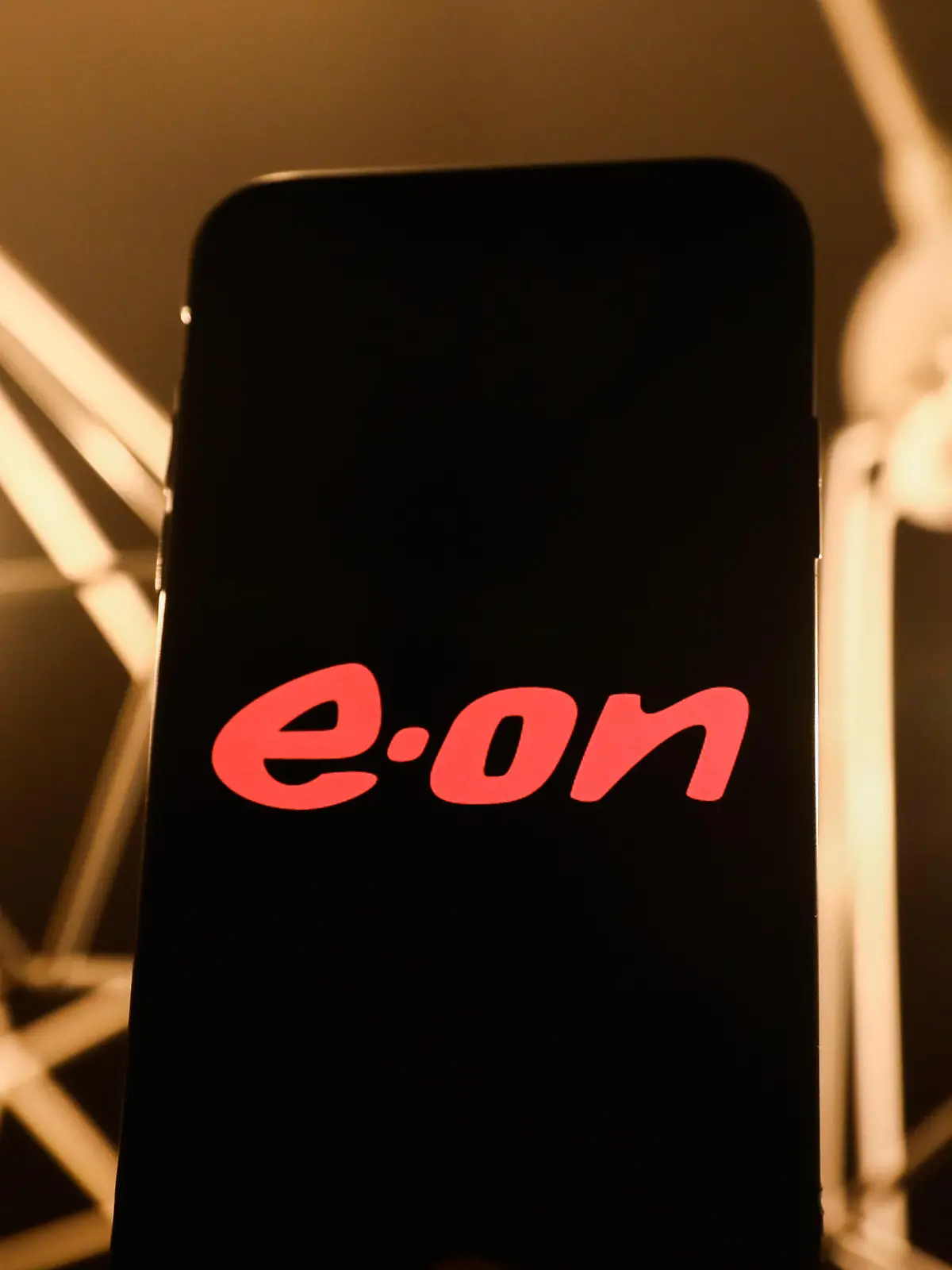E.ON logo displayed on a phone screen and light bulbs in home lamps are seen in this illustration photo taken in Krakow, Poland on January 22, 2022. (Photo by Jakub Porzycki/NurPhoto)