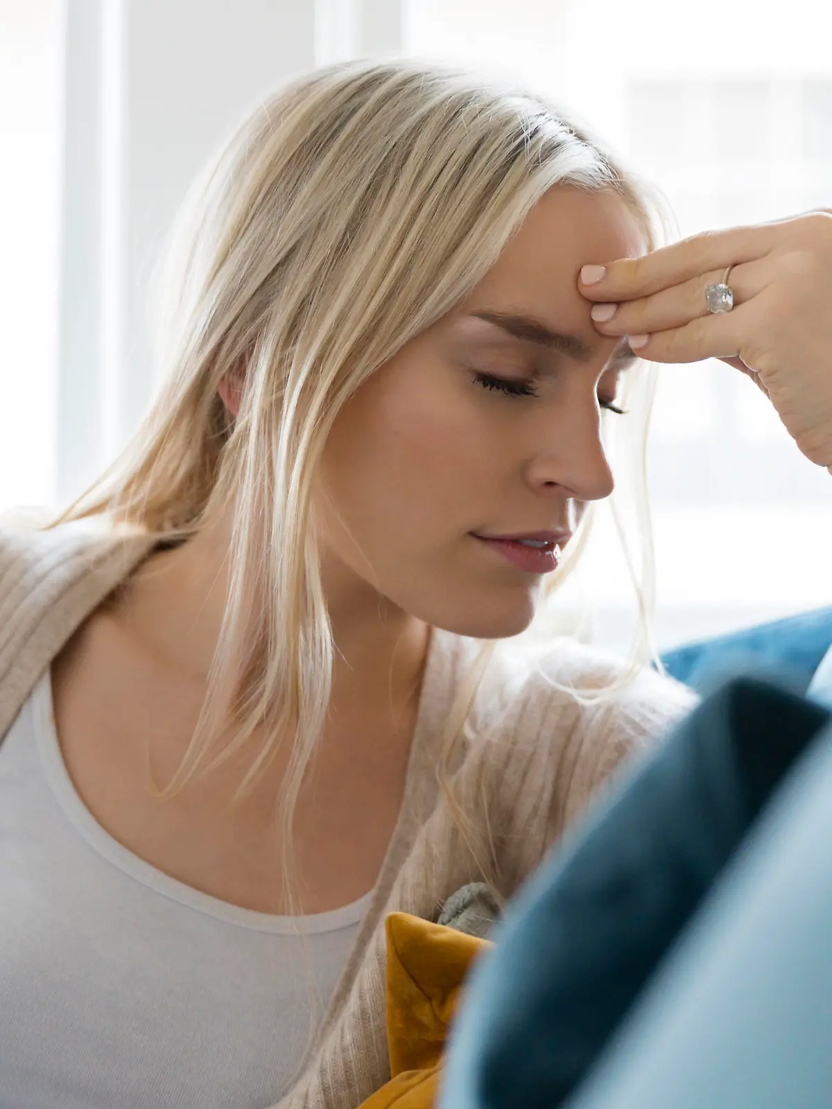 Woman with headache siting on sofa, Frau mit dem Kopfweh-Stationieren auf der Couch