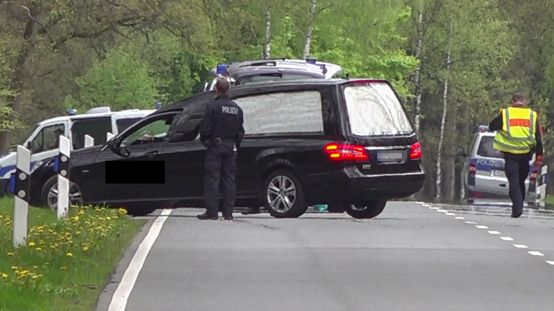 18.05.2021, Niedersachsen, Bispingen: In einem Waldstück unweit von Bispingen fährt ein Leichenwagen von der Bundesstraße in den Wald. Dort wurde eine Kinderleiche gefunden. Eine Frau und ihr vierjähriger Sohn waren am 16. Mai tot in einem Haus in Bispingen entdeckt worden. Beide hätten Spuren von Gewalt aufgezeigt, teilten Polizei und Staatsanwaltschaft mit. Die elfjährige Tochter wurde vermisst. Foto: Tnn/dpa +++ dpa-Bildfunk +++
