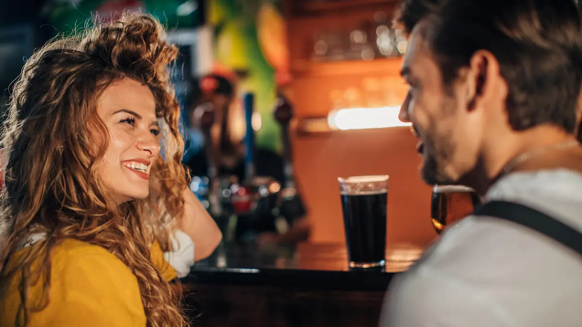 Young couple drinking beer in pub