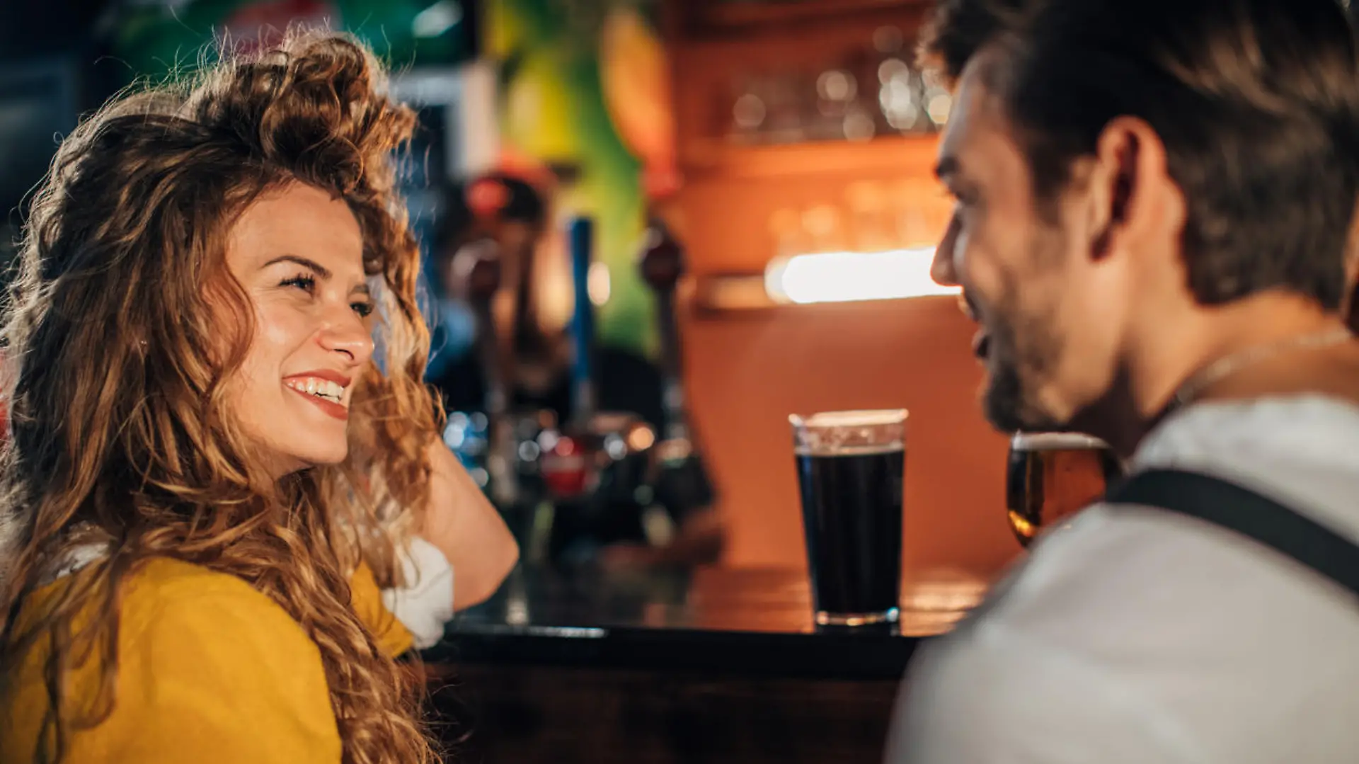 Young couple drinking beer in pub