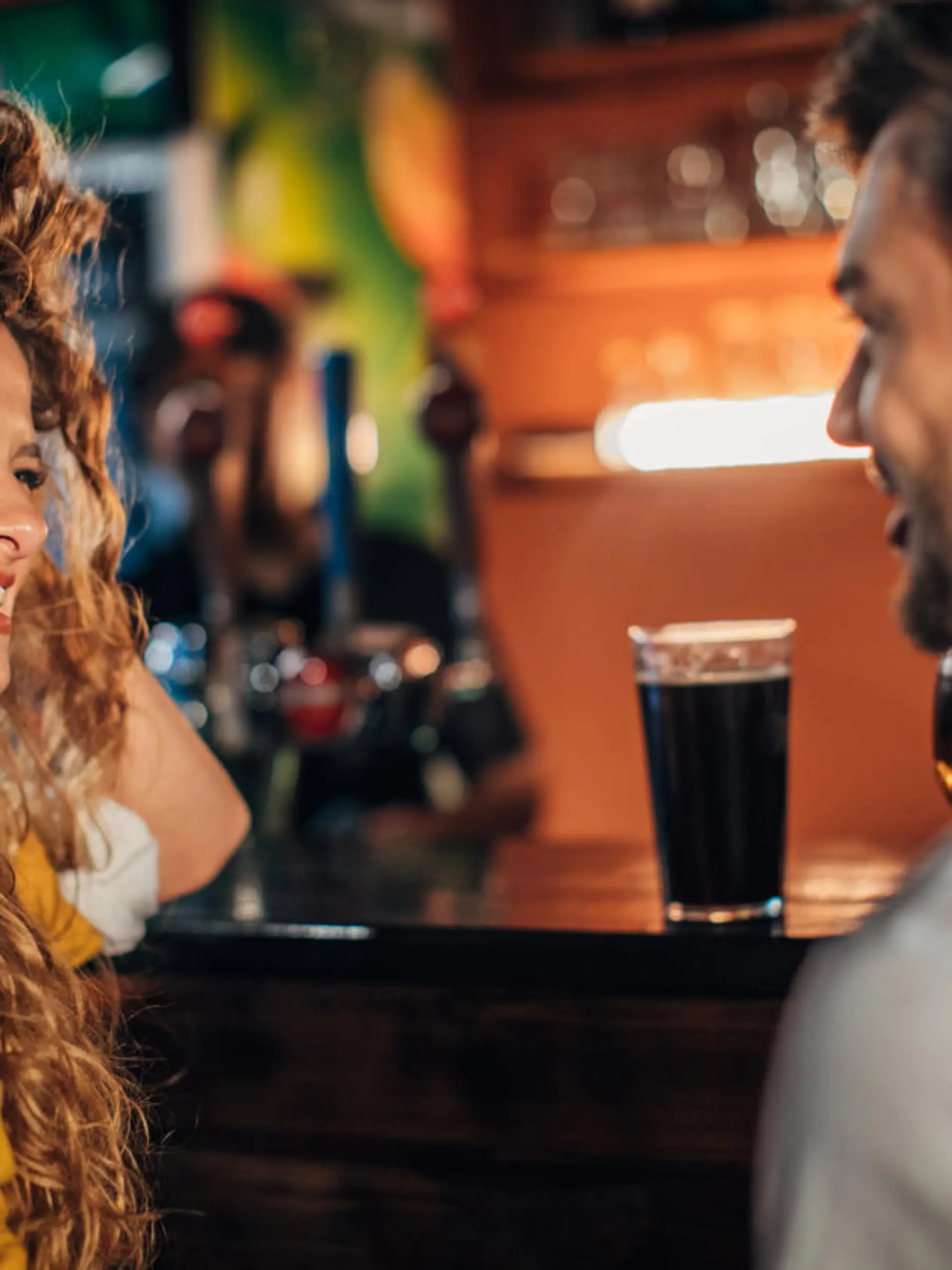 Young couple drinking beer in pub