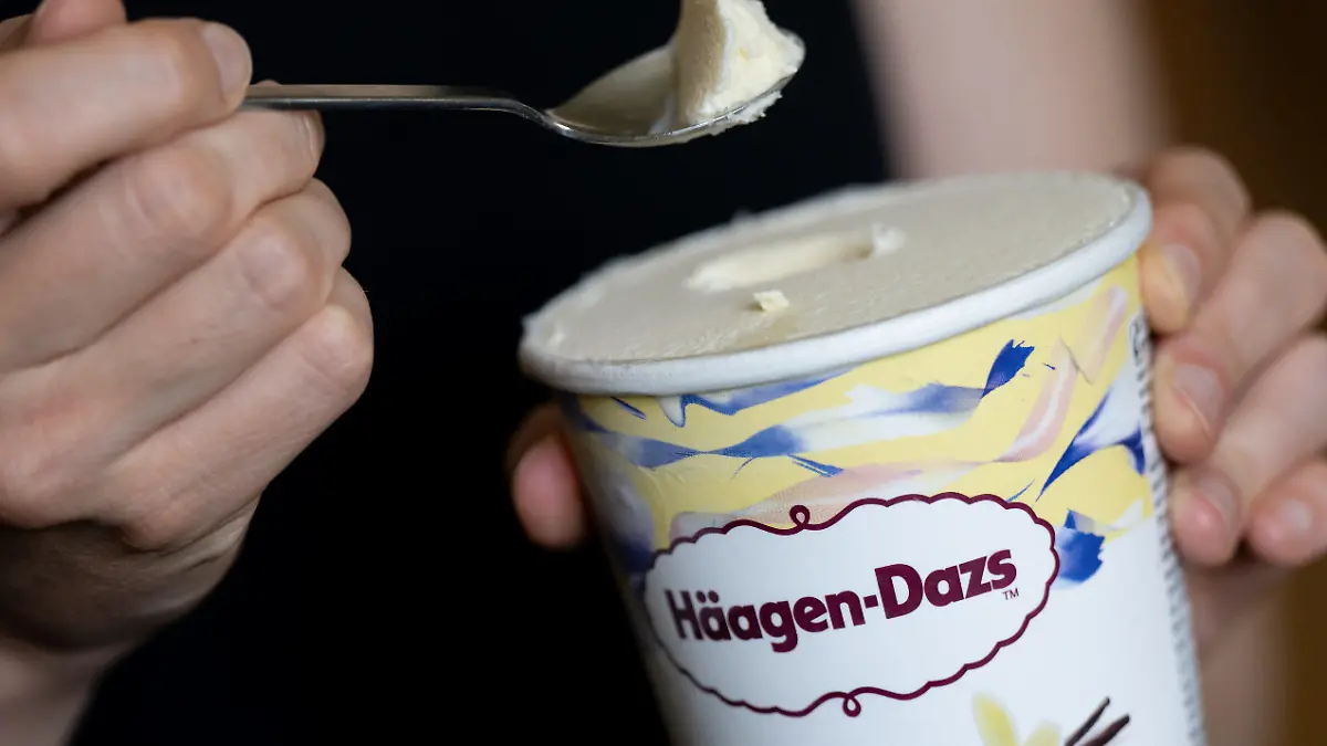 14.07.2022, Bayern, München: Eine Frau hält einen Löffel und einen Becher Eis "Vanilla" von Häagen-Dazs in den Händen. Der Hersteller General Mills ruft Produkte von Häagen-Dazs mit der Geschmacksrichtung «Vanilla» zurück. Es könne nicht ausgeschlossen werden, dass sich in den Produkten Rückstände von Ethylenoxid befinden. Es gehe um die Größen 460 ml, 95 ml und die Classic Collection 4x95 ml mit dem Mindesthaltbarkeitsdatum 21. Mai 2023. Foto: Sven Hoppe/dpa - ACHTUNG: Nur zur redaktionellen Verwendung und nur mit vollständiger Nennung des vorstehenden Credits +++ dpa-Bildfunk +++