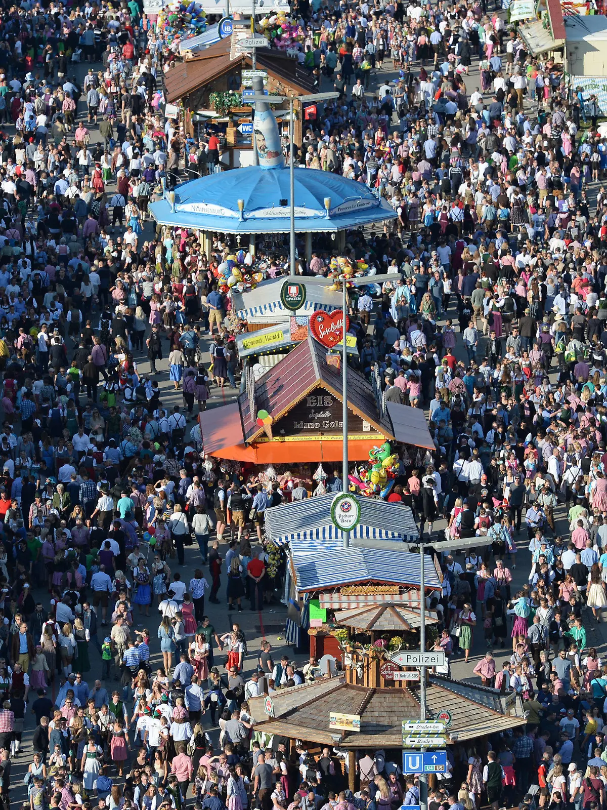 ARCHIV - 24.09.2016, Bayern, München: Zahlreiche Menschen gehen bei Sonnenschein über das Oktoberfest-Gelände. (zu dpa: «Countdown zur Wiesn zwischen Pandemie, Inflation und Energiekrise») Foto: picture alliance / dpa +++ dpa-Bildfunk +++
