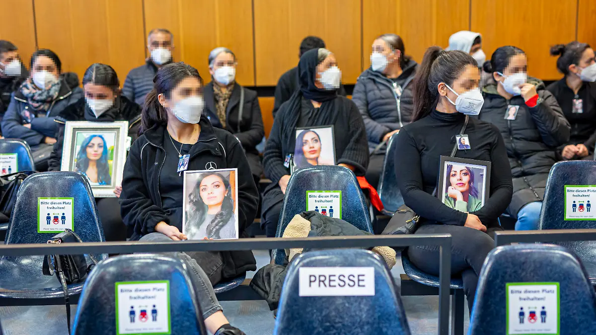 dpatopbilder - 14.10.2022, Niedersachsen, Hildesheim: Angehörige der Getöteten sitzen mit Porträtfotos der Frau bei Prozessauftakt in einem Saal vom Landgericht Hildesheim. Einem Angeklagten wird vorgeworfen, im Mai 2022 in Burgdorf (Region Hannover) seine Ehefrau aus niederen Beweggründen heimtückisch ermordet zu haben. Foto: Moritz Frankenberg/dpa - Nutzung nur nach schriftlicher Vereinbarung mit der dpa +++ dpa-Bildfunk +++