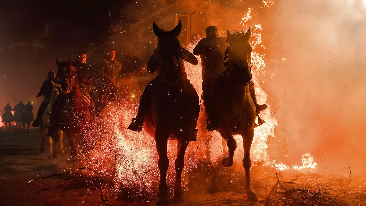 January 16, 2023, San Bartolome de Pinares, Spain: A group of horsemen ride through a bonfire made with pine tree branches in the village of San Bartolome de Pinares during the traditional religious festival of Las Luminarias in honour of San Antonio Abad Saint Anthony, patron saint of animals celebrated every night of January 16. The riders take part in a procession with their horses and donkeys, crossing the multiple bonfires lit on the streets of the City. San Bartolome de Pinares Spain - ZUMAs197 20230116_zaa_s197_303 Copyright: xGuillermoxGutierrezx