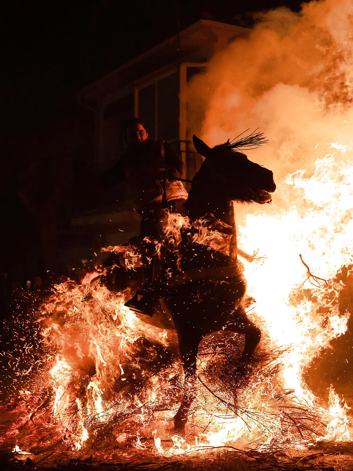 January 16, 2023, San Bartolome de Pinares, Spain: A horseman rides through a bonfire made with pine tree branches in the village of San Bartolome de Pinares during the traditional religious festival of Las Luminarias in honour of San Antonio Abad Saint Anthony, patron saint of animals celebrated every night of January 16. The riders take part in a procession with their horses and donkeys, crossing the multiple bonfires lit on the streets of the City. San Bartolome de Pinares Spain - ZUMAs197 20230116_zaa_s197_301 Copyright: xGuillermoxGutierrezx
