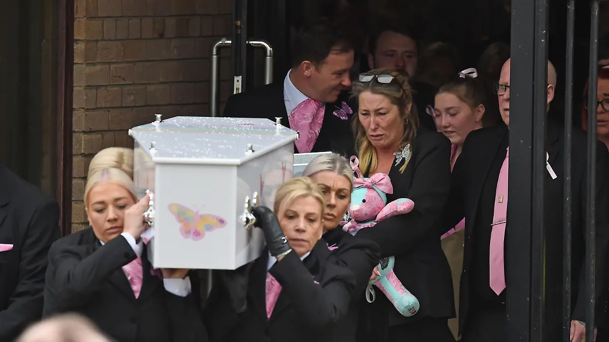 15.09.2022, Großbritannien, Liverpool: Olivias Mutter Cheryl Korbel geht hinter dem Sarg von Olivia als dieser nach ihrer Beerdigung aus der St. Margaret Mary's Church in Knotty Ash getragen wird. Das neunjährige Mädchen war am 22. August in ihrem Haus in Dovecot erschossen worden. Foto: Peter Powell/PA Wire/dpa +++ dpa-Bildfunk +++