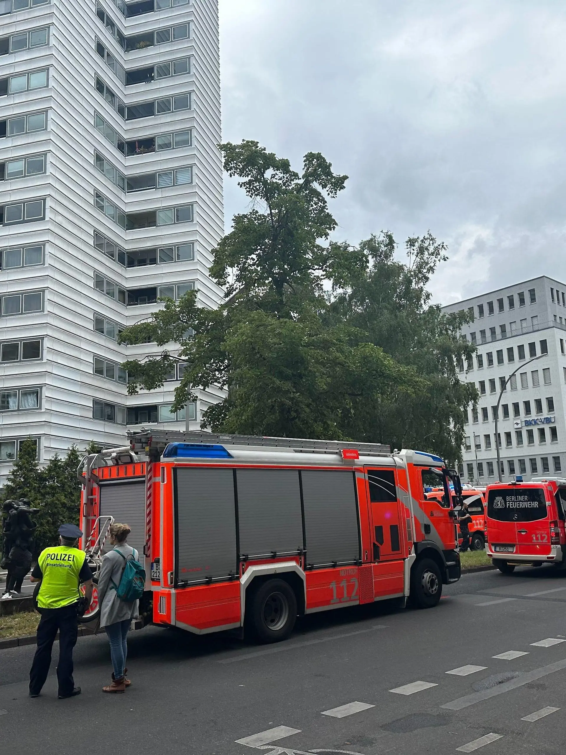 28.07.2023, Berlin: Einsatzkräfte der einem Hochhaus stehen vor einem Hochhaus auf der Straße. Zwei Menschen sind wegen eines Brandes in einem Hochhaus aus dem Gebäude gesprungen und gestorben. Das Feuer sei am Freitag im zehnten Stock eines zwölfgeschossigen Hochhauses ausgebrochen. Foto: Annette Riedl/dpa +++ dpa-Bildfunk +++