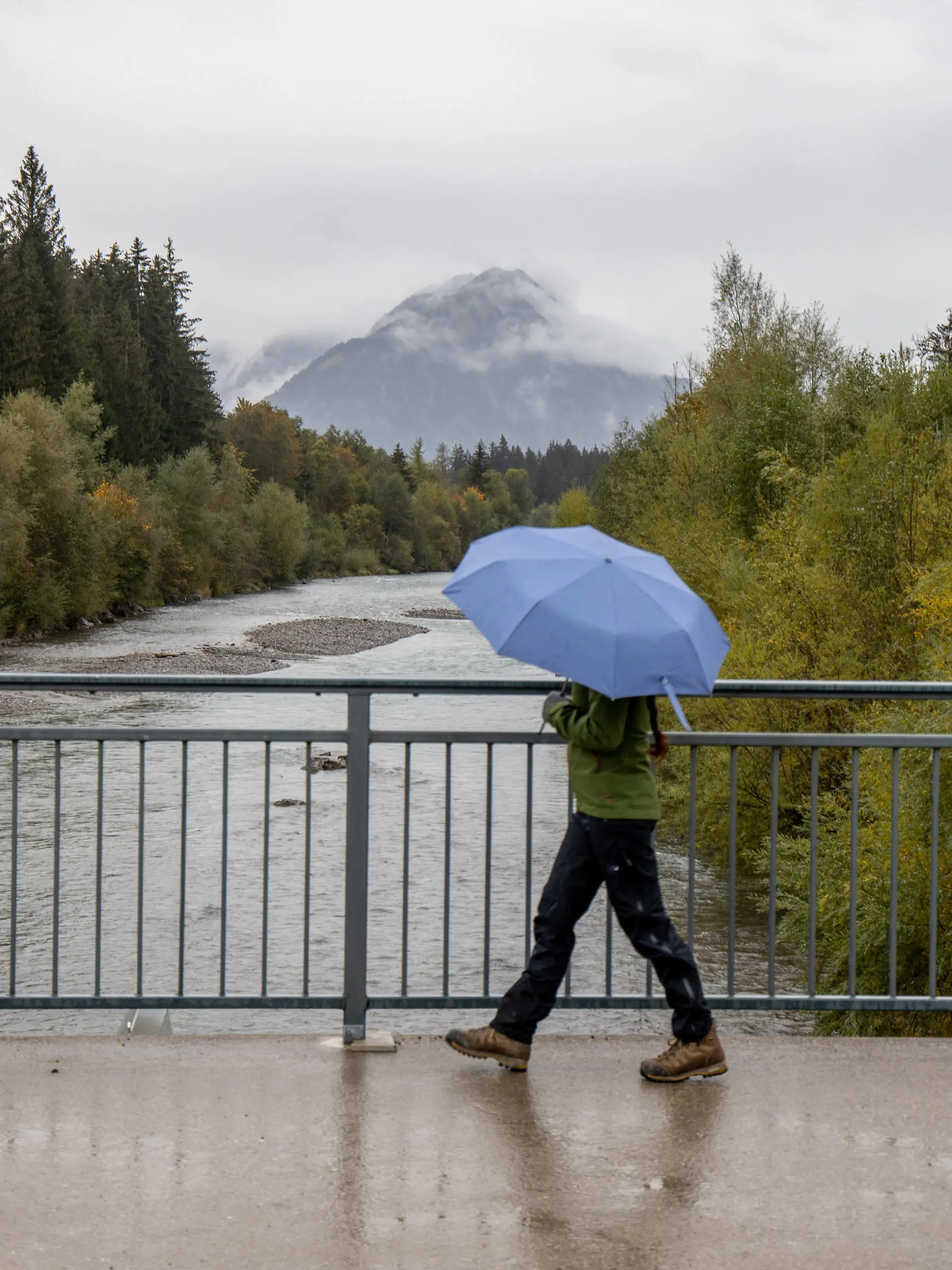  Regenwetter im Allgäu 10.10.2020, Fischen Bayern: Herbstliches Wetter mit Regen, eine Frau mit Regenschirm läuft über eine Brücke über die Iller., Fischen Deutschland *** Rainy weather in Allgäu 10 10 2020, Fishing Bavaria Autumnal weather with rain, a woman with umbrella walks over a bridge over the Iller , Fishing Germany