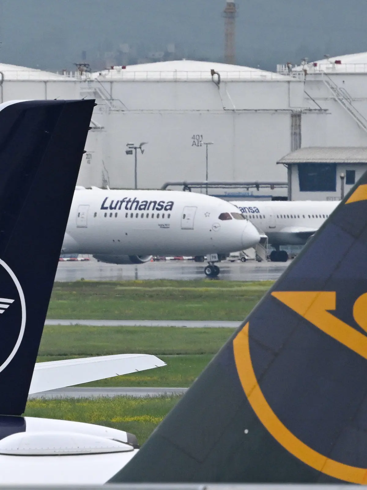 PRODUKTION - 09.05.2023, Hessen, Frankfurt/Main: Flugzeuge der Lufthansa und von Condor parken nahe der Baustelle von Terminal 3 des Frankfurter Flughafens. Die Arbeiten für das neue Terminal 3 am größten deutschen Flughafen sind in vollem Gang. Der ganze Abschnitt soll 2026 in Betrieb gehen. Foto: Arne Dedert/dpa +++ dpa-Bildfunk +++