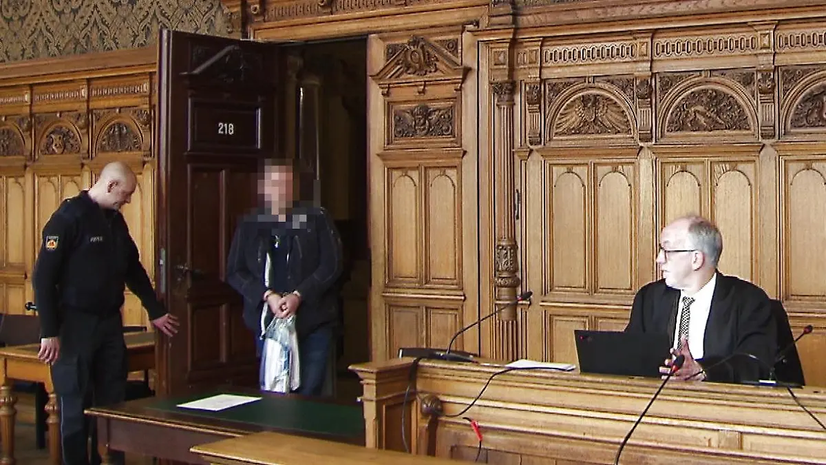 Der Angeklagte Walter B. betritt den Gerichtssaal mit einer Tasche voller Unterlagen.
