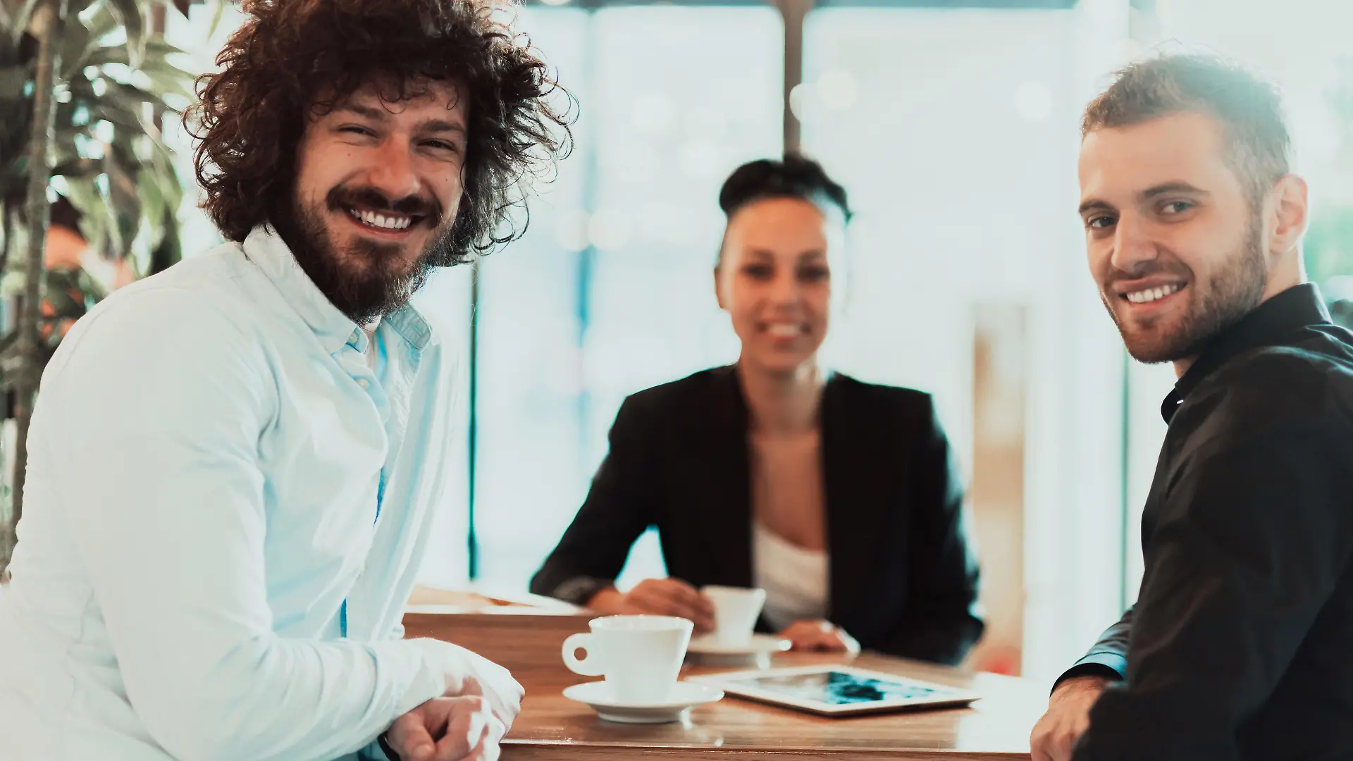 A group of businesspeople on a coffee break use laptops, tablets, and smartphones while talking about new business projects. business concept. || Modellfreigabe vorhanden