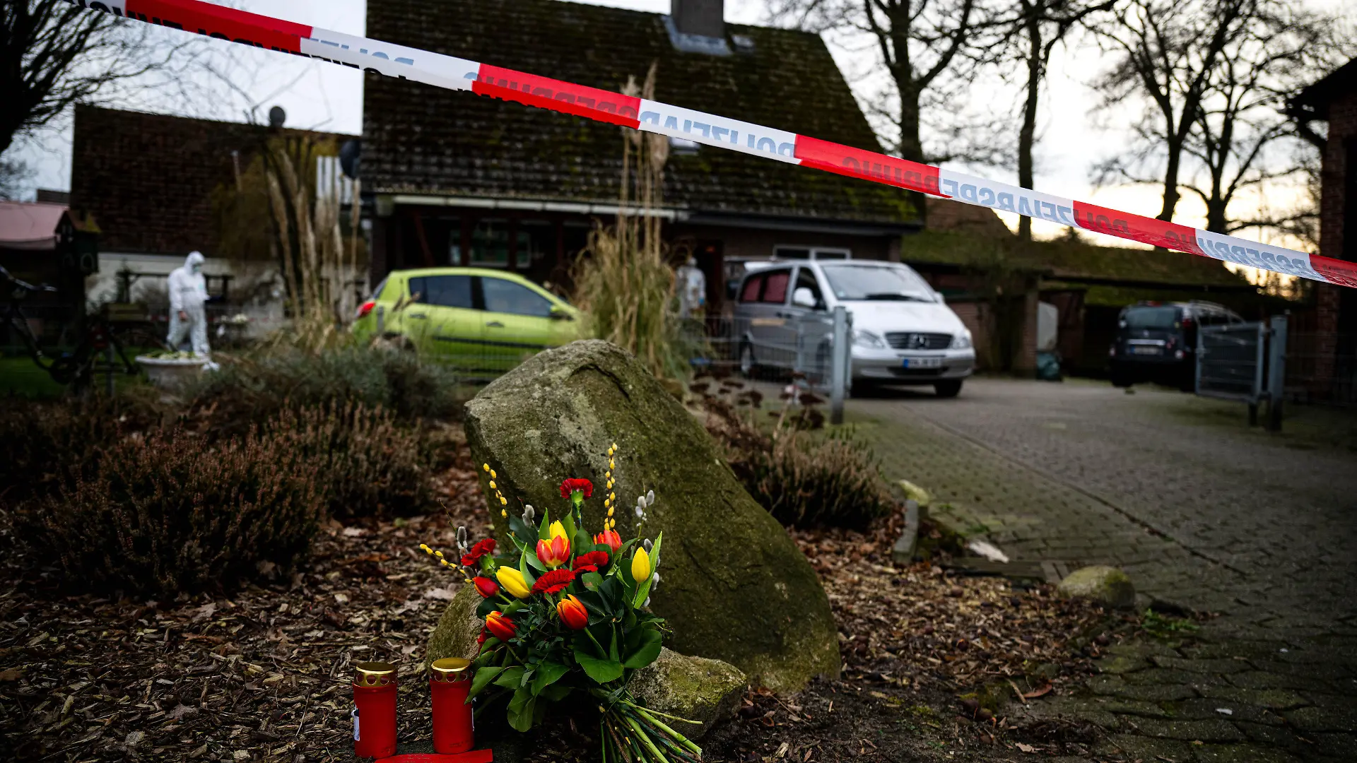 dpatopbilder - 01.03.2024, Niedersachsen, Scheeßel: Blumen und Kerzen liegen vor einem Einfamilienhaus in der Gemeinde Scheeßel. Nach der Tötung von drei Erwachsenen und einem dreijährigen Kind im niedersächsischen Landkreis Rotenburg (Wümme) hat ein Ermittlungsrichter am Freitag Haftbefehl wegen Mordes gegen einen Bundeswehrsoldaten erlassen, wie die Polizei mitteilte. Foto: Sina Schuldt/dpa +++ dpa-Bildfunk +++