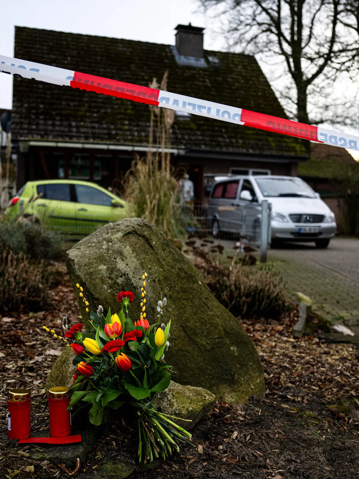 dpatopbilder - 01.03.2024, Niedersachsen, Scheeßel: Blumen und Kerzen liegen vor einem Einfamilienhaus in der Gemeinde Scheeßel. Nach der Tötung von drei Erwachsenen und einem dreijährigen Kind im niedersächsischen Landkreis Rotenburg (Wümme) hat ein Ermittlungsrichter am Freitag Haftbefehl wegen Mordes gegen einen Bundeswehrsoldaten erlassen, wie die Polizei mitteilte. Foto: Sina Schuldt/dpa +++ dpa-Bildfunk +++