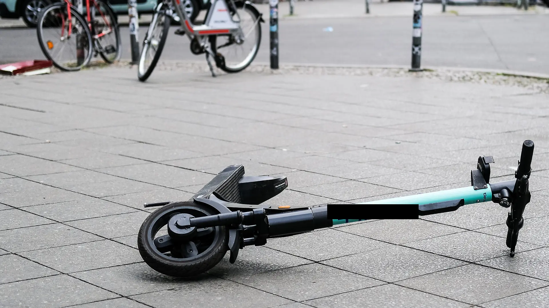 ARCHIV - 24.07.2020, Berlin: Ein E-Scooter liegt umgekippt mitten auf dem Gehweg in der Revaler Straße in Friedrichshain. Nach einem tödlichen Sturz eines Radfahrers über einen E-Roller in Gelsenkirchen ermittelt die Polizei weiter zum Hintergrund des Unfalls. (zu dpa: «Tödlicher Sturz von Radfahrer über E-Roller - Ermittlungen laufen») Foto: Jens Kalaene/dpa-Zentralbild/dpa +++ dpa-Bildfunk +++
