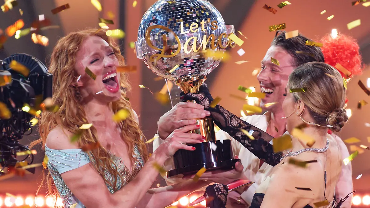 20.05.2023, Nordrhein-Westfalen, Köln: Model Anna Ermakova (l) und ihr Profi-Tanzpartner Valentin Lusin jubeln neben Victoria Swarovski, Moderatorin, über ihren Sieg mit der Trophäe nach dem Finale der RTL Live-Tanzshow "Let's Dance". Foto: Henning Kaiser/dpa +++ dpa-Bildfunk +++