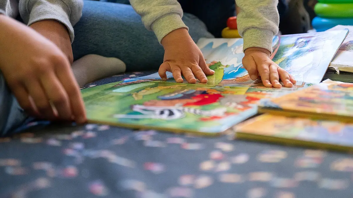 Eine Erzieherin liest in einer Kita Kindern vor.