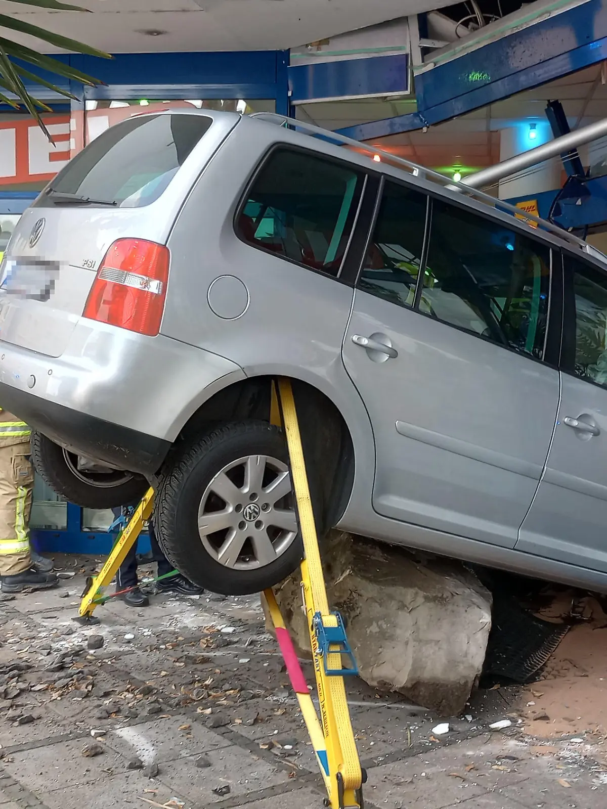 19.07.2023, Nordrhein-Westfalen, Siegburg: Ein Pkw steckt in der Scheibe eines Sonnenstudios. Ein Autofahrer ist in Siegburg bei Bonn von der Straße abgekommen und in die Glasfront eines Sonnenstudios gekracht. Der 39-Jährige und eine 27 Jahre alte Frau, die das Geschäft gerade verlassen wollte, seien bei dem Unfall am Mittwoch verletzt worden, teilte die Polizei mit. Foto: Marius Fuhrmann/dpa - ACHTUNG: Das Kennzeichen wurde aus rechtlichen Gründen gepixelt. +++ dpa-Bildfunk +++