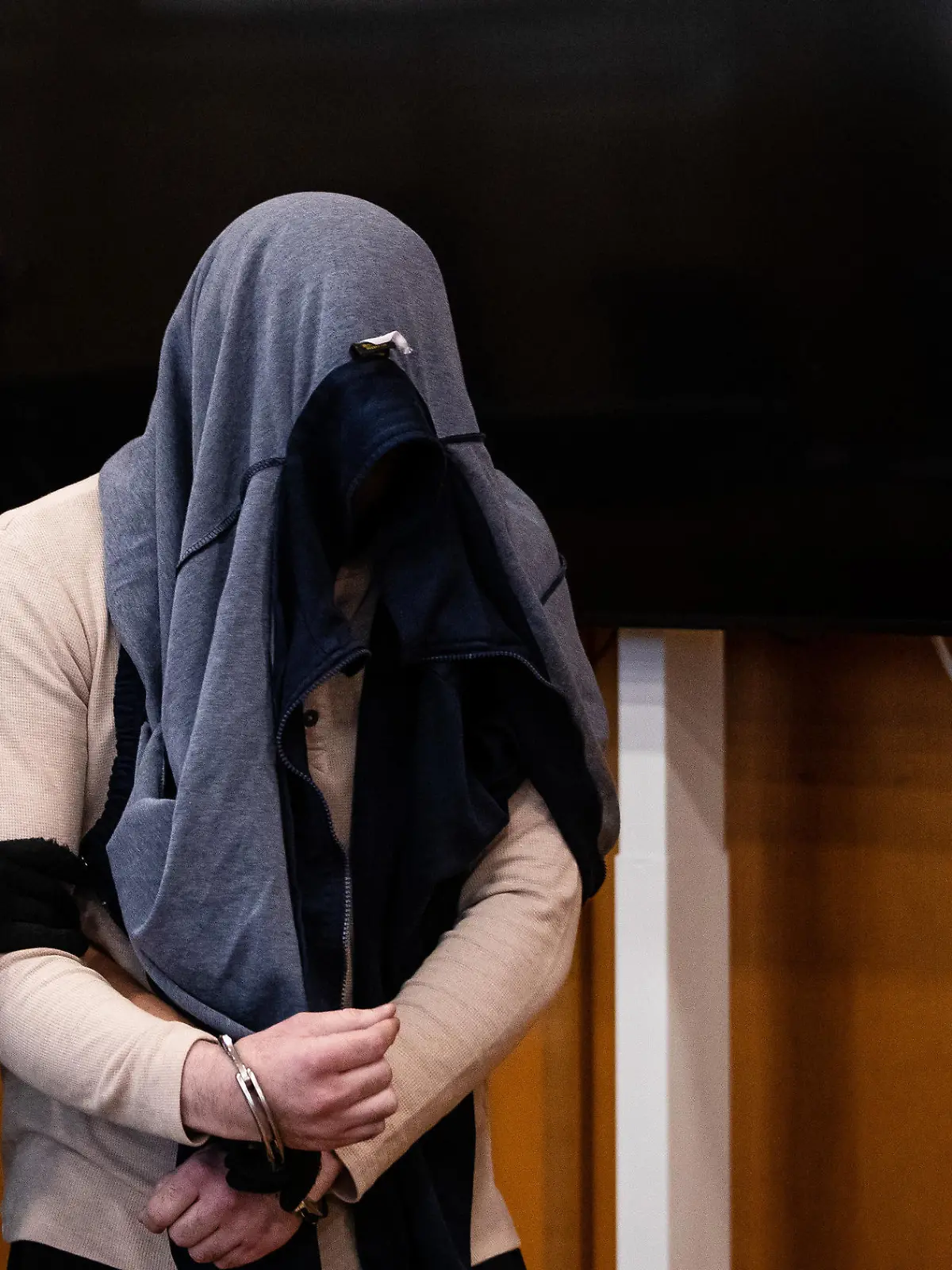 28.07.2023, Baden-Württemberg, Heilbronn: Ein Angeklagter wird zu Beginn eines Prozesses wegen Mordes von einer Justizbeamtin in einen Gerichtssaal des Landgerichts Heilbronn geführt. Dem Angeklagten wird vorgeworfen, zwei Seniorinnen in Schwäbisch Hall und Umgebung umgebracht zu haben. Foto: Christoph Schmidt/dpa +++ dpa-Bildfunk +++