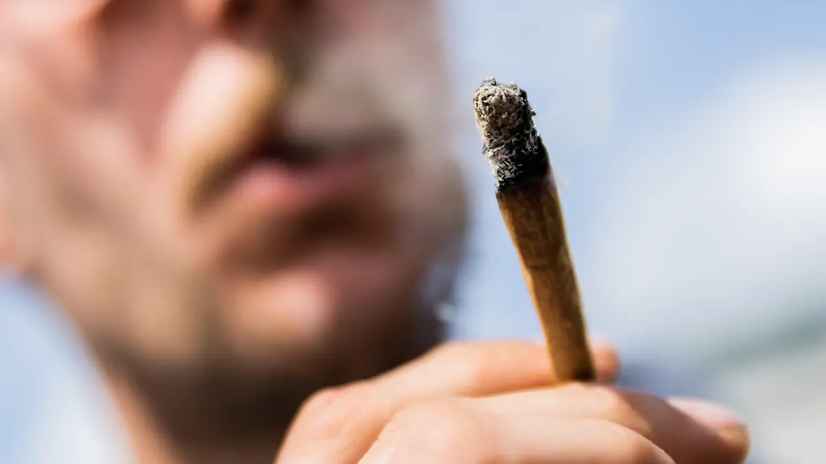 ARCHIV - 07.05.2022, Berlin: Ein Mann raucht bei einer Demonstrationen für eine Legalisierung von Cannabis im Mai 2022 am Brandenburger Tor einen Joint mit Medizinalcannabis. (zu dpa: «Gehalt von Rauschmittel THC in Haschisch verdoppelt») Foto: Christoph Soeder/dpa +++ dpa-Bildfunk +++