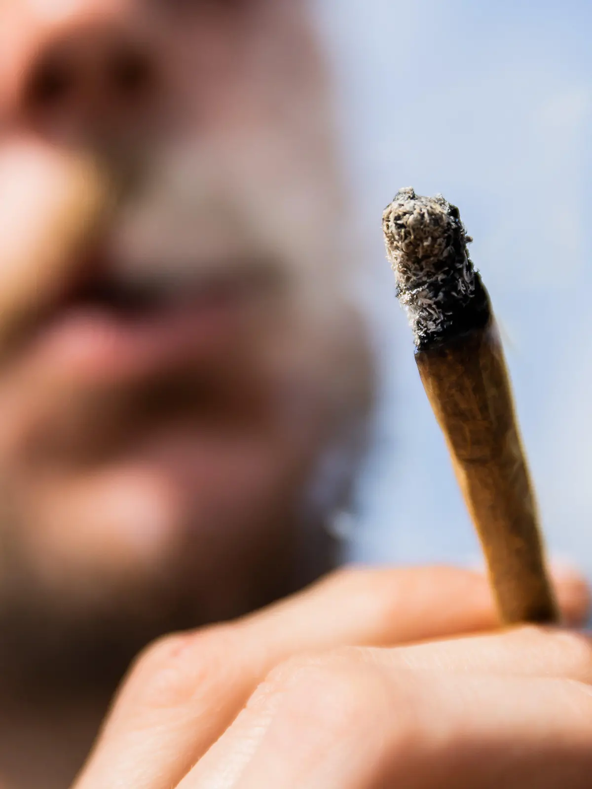 ARCHIV - 07.05.2022, Berlin: Ein Mann raucht bei einer Demonstrationen für eine Legalisierung von Cannabis im Mai 2022 am Brandenburger Tor einen Joint mit Medizinalcannabis. (zu dpa: «Gehalt von Rauschmittel THC in Haschisch verdoppelt») Foto: Christoph Soeder/dpa +++ dpa-Bildfunk +++