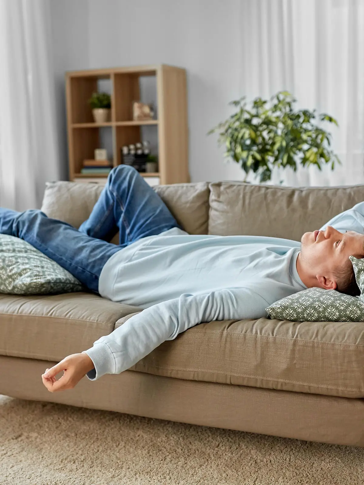 people, boredom and depression concept - bored or lazy young man lying on sofa at home || Modellfreigabe vorhanden