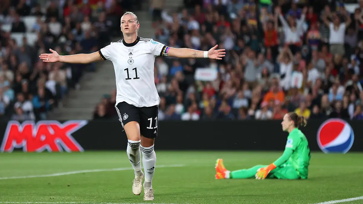 MILTON KEYNES, ENGLAND - JULY 27: Alexandra Popp of Germany celebrates after scoring their side's first goal as Pauline Peyraud-Magnin of France looks dejected during the UEFA Women's Euro 2022 Semi Final match between Germany and France at Stadium MK on July 27, 2022 in Milton Keynes, England. (Photo by Alex Pantling/Getty Images)