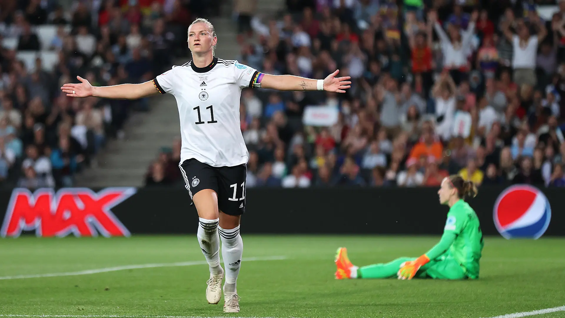 MILTON KEYNES, ENGLAND - JULY 27: Alexandra Popp of Germany celebrates after scoring their side's first goal as Pauline Peyraud-Magnin of France looks dejected during the UEFA Women's Euro 2022 Semi Final match between Germany and France at Stadium MK on July 27, 2022 in Milton Keynes, England. (Photo by Alex Pantling/Getty Images)