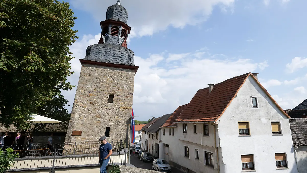 11.09.2022, Rheinland-Pfalz, Gau-Weinheim: Eine Fahne hängt am ·schiefen Turm· von Gau-Weinheim. Durch die Neigung von 5,4277 Grad gilt der ehemalige Wehrturm der kleinen Gemeinde in Rheinland-Pfalz nach Einschätzung des Rekord-Instituts für Deutschland (RID) als ·schiefster Turm der Welt·. Eine Messung im Juli habe die Neigung des Turmes neben der Kirche bestätigt. Foto: Boris Roessler/dpa +++ dpa-Bildfunk +++