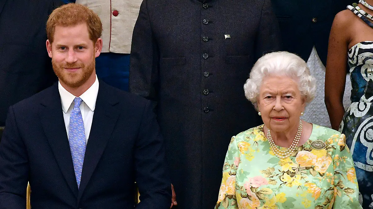 FILE - In this Tuesday, June 26, 2018 file photo, Britain's Queen Elizabeth, Prince Harry and Meghan, Duchess of Sussex pose for a group photo at the Queen's Young Leaders Awards Ceremony at Buckingham Palace in London. Queen Elizabeth II, Britain’s longest-reigning monarch and a rock of stability across much of a turbulent century, has died. She was 96. Buckingham Palace made the announcement in a statement on Thursday Sept. 8, 2022.(John Stillwell/Pool Photo via AP, File)