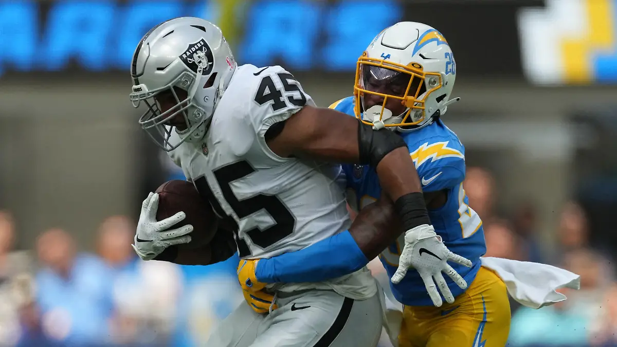 Sep 11, 2022; Inglewood, California, USA; Las Vegas Raiders fullback Jakob Johnson (45) is tackled by Los Angeles Chargers cornerback Asante Samuel Jr. (26) in the first half at SoFi Stadium. Mandatory Credit: Kirby Lee-USA TODAY Sports