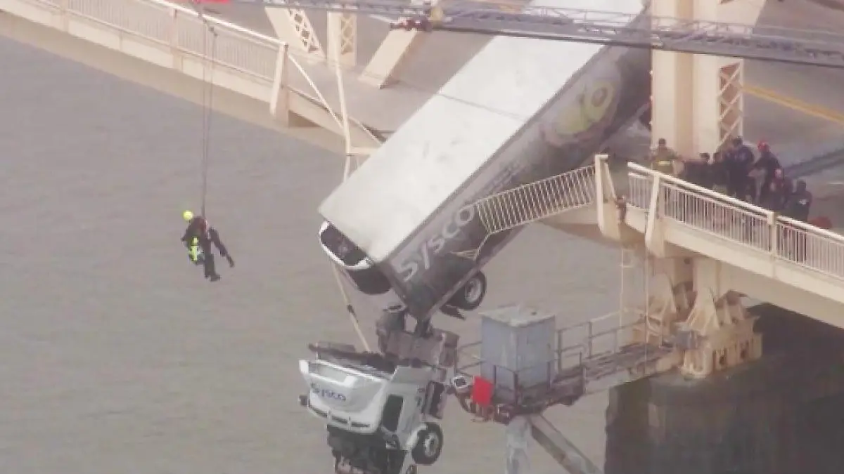 Ein Retter seilt sich zu der LKW-Fahrerin ab,