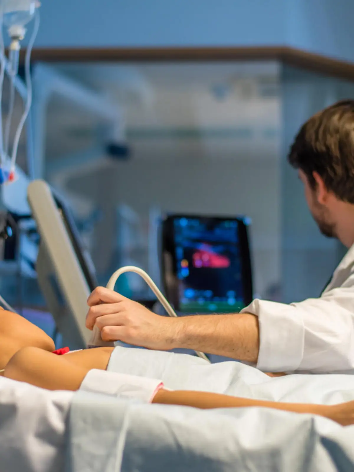 Doctor checking heart ultrasound scan of child patient in operating theatre.